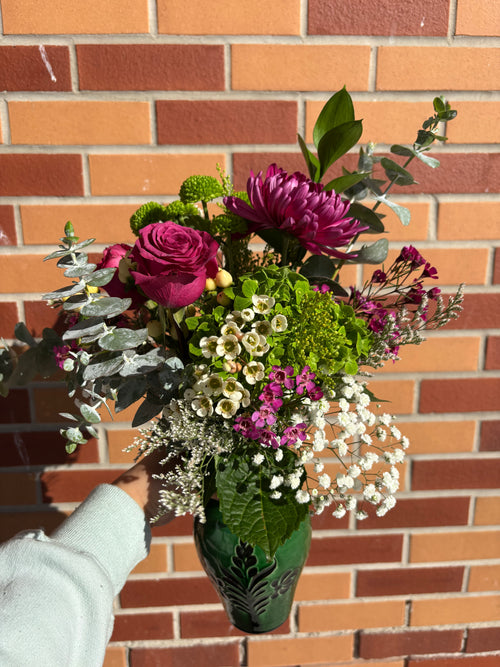 a custom floral design in a green vase