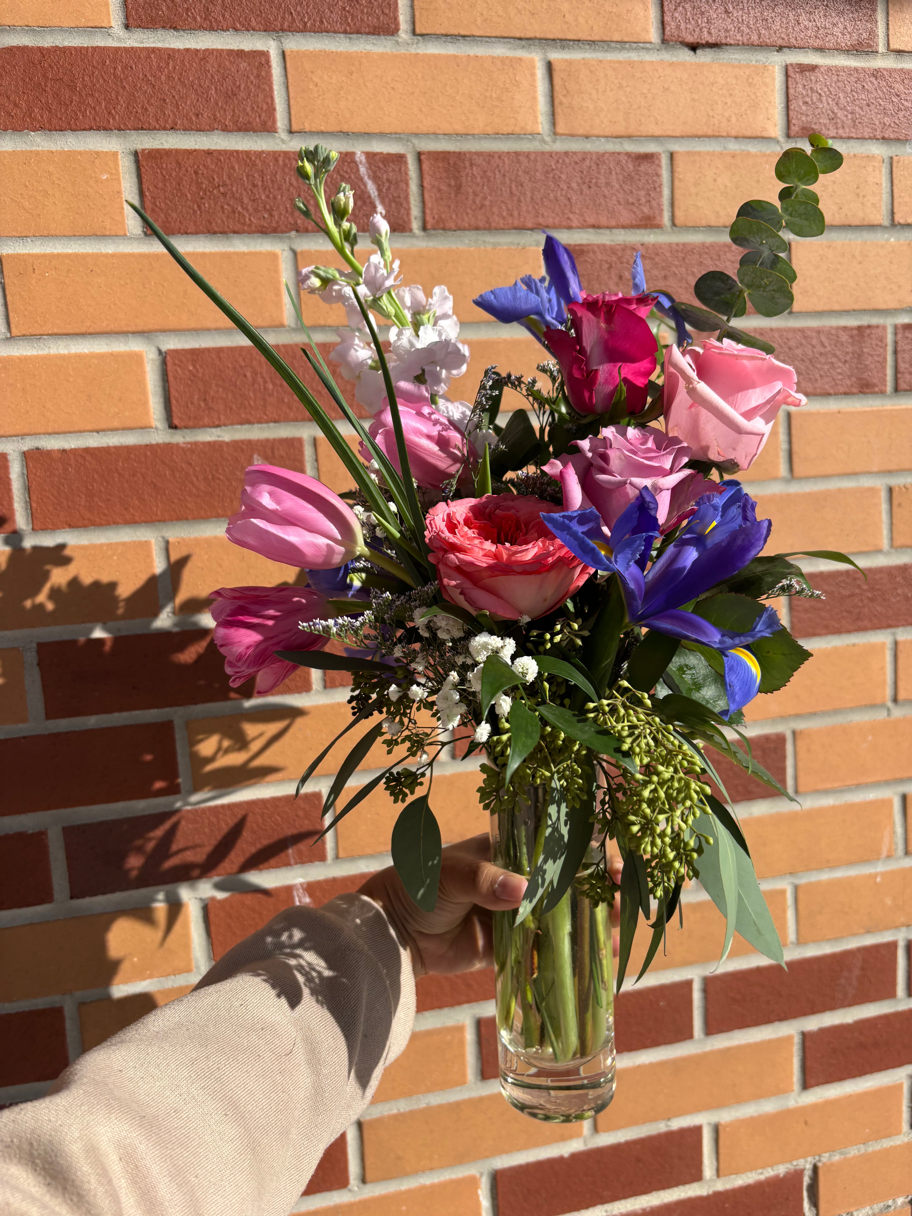 Artistic, minimal, and quietly striking, Eye of the Beholder proves that simplicity can be breathtaking. Designed with a small selection of premium seasonal blooms and fresh greens, this piece is thoughtful and full of intention.
A meaningful gift or a beautiful accent for a desk, bedside, or small table.